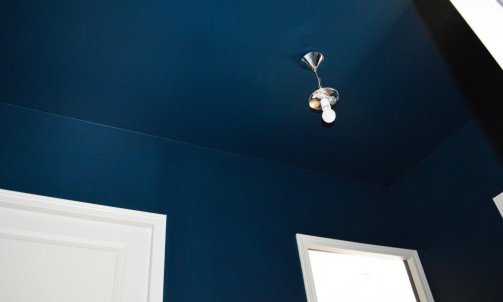Dans le dégagement, un bleu soutenu, Bleu Mayotte CH1 0900 (Seigneurie) est appliqué aux murs et au plafond pour en faire un véritable élément de passage vers les chambres. Peintes en Beige Brêche dans la continuité du reste de l'appartement, les portes viennent rythmer cet espace. 